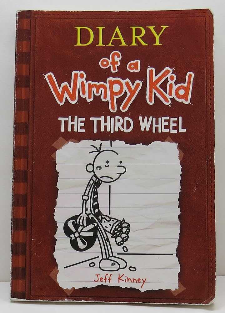 Used paperback book cover of The Third Wheel by Jeff Kinney, showing colorful cartoon-style illustration with Greg Heffley character, book 7 in Diary of a Wimpy Kid series